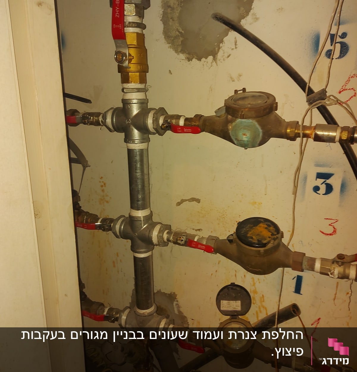 צינורות מים עם ברזים ומדי מים על קיר